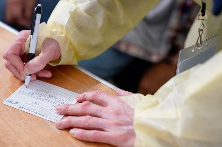 Doctor fills out a COVID-19 vaccination record card at a vaccination site at the Corsi Houses in East Harlem on January 15th, 2021.